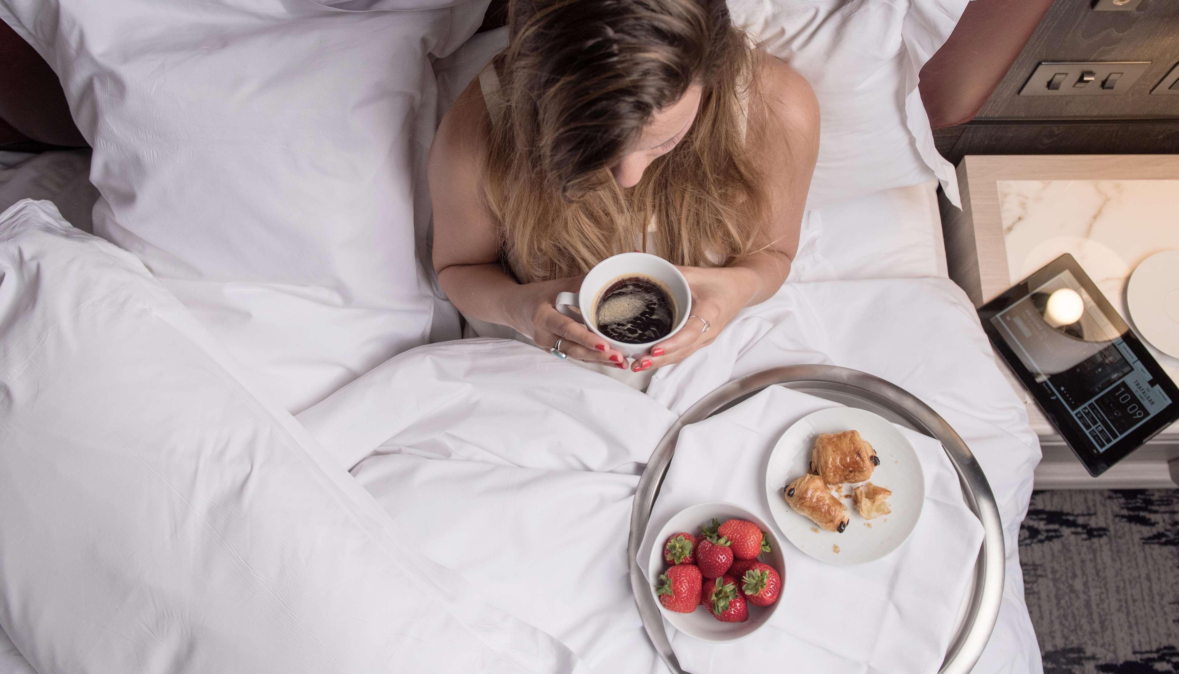 特拉法加圣詹姆斯，伦敦希尔顿Curio Collection酒店 外观 照片 A woman drinking coffee in bed